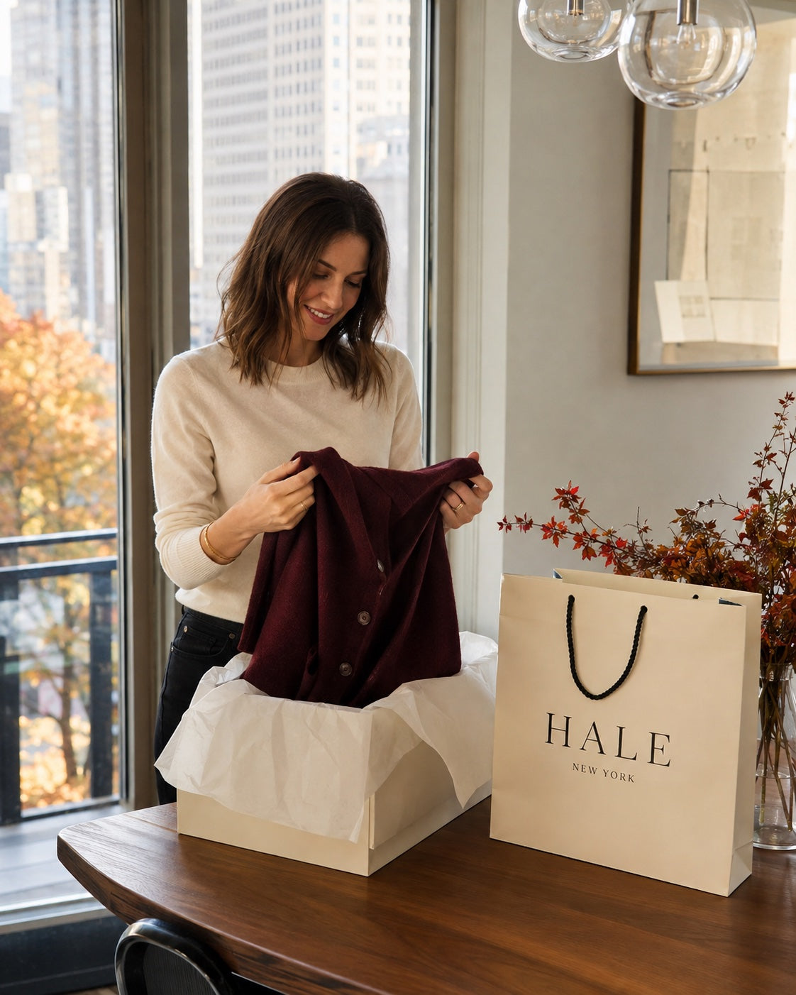 Unpacking a cardigan beside Hale New York packaging